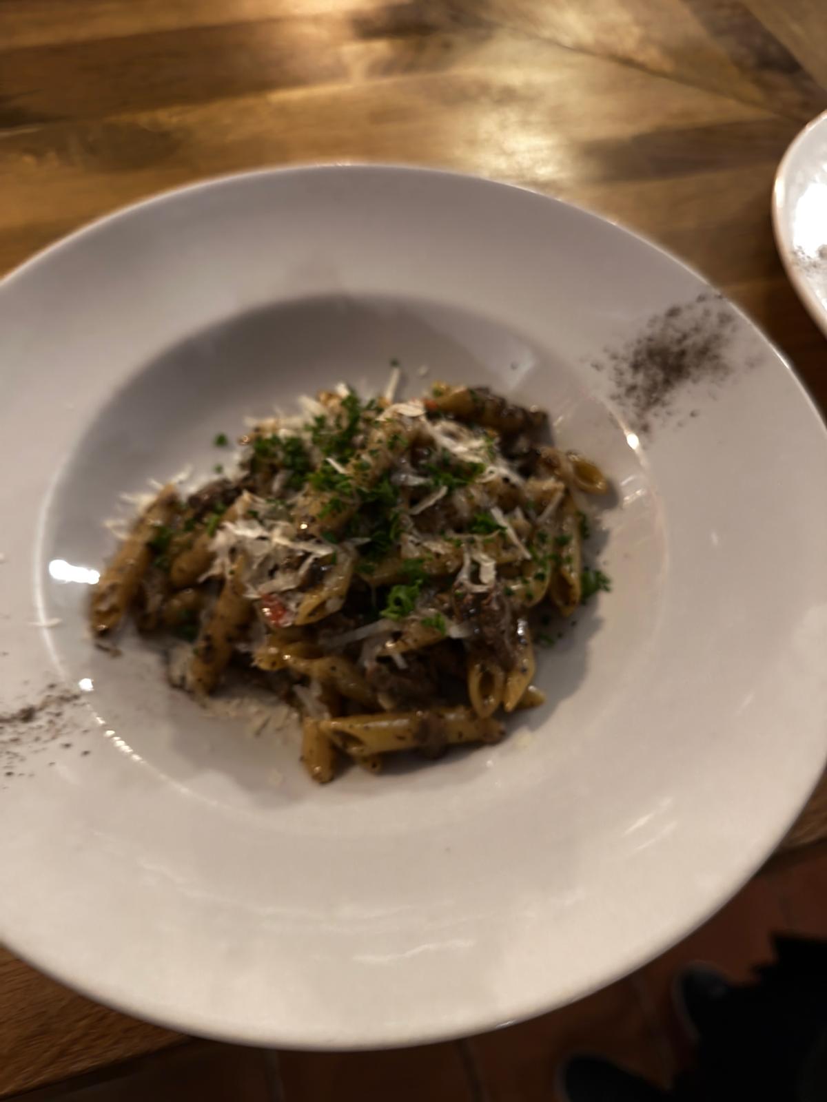 Pasta på en hvid tallerken på et træbord